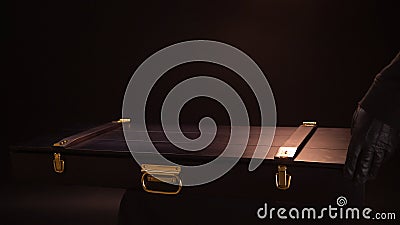 Close up of ancient valuable sward lying inside of wooden case with gold clasps. Stock footage. Hands in leather gloves Stock Photo