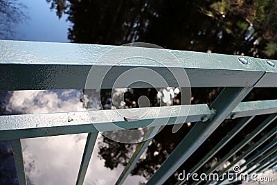 Close up angled photo of a grey steel railing on a bridge. Stock Photo