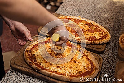 Close up of anonimous pizza chef slicing appetising pizza Stock Photo