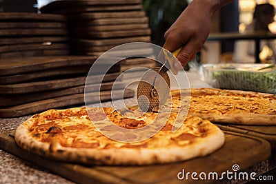 Close up of anonimous pizza chef slicing appetising pizza Stock Photo