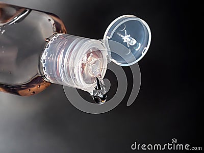 Close-up of antibacterial hand sanitiser bottle, showing gel droplet pouring out. Stock Photo