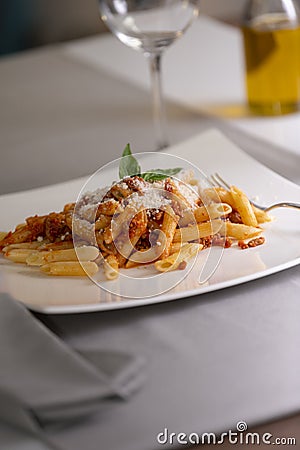 Close up of an appetizing plate of macaroni with bolognese sauce and grated cheese. Stock Photo