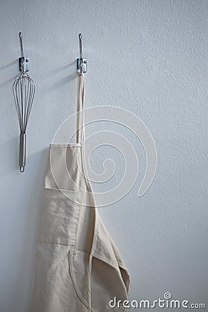 Apron and whisker hanging on hook Stock Photo