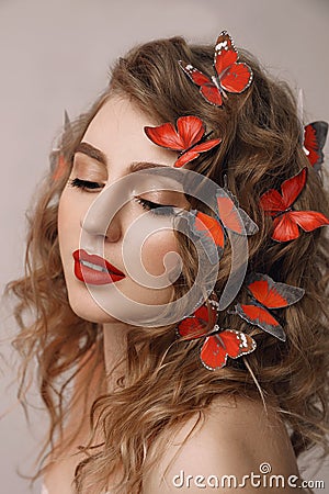 Close up art portrait of agirl with butterflies in her hair, european female with red lips and closed eyes Stock Photo