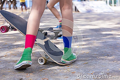 Close-up Asian girl surf skate or skateboard outdoors on beautiful morning. Happy young girl play surf skate at ramp park on Stock Photo