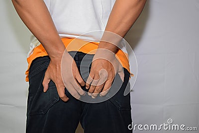 Close up Asian man shows he had hemorrhoid symptoms rectal cancer isolated on white background Stock Photo