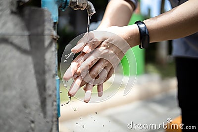 Close up,Asian people washing her hands,cleaning dirty hands from a faucet,tap water running weakly in public places in the city, Stock Photo
