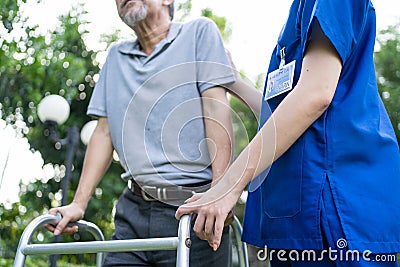 Close up of Asian young woman nurse visit and take care disabled senior elderly man. Caregiver doctor serve physical therapy for o Stock Photo