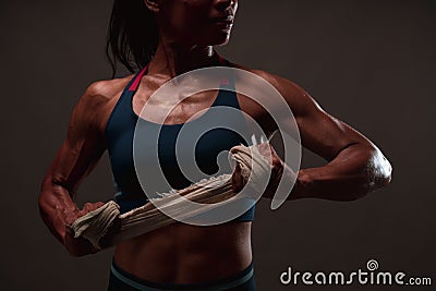 Close up of athletic healthy lean tone top body of asian woman holding white strap with both hands preparing for training or Stock Photo