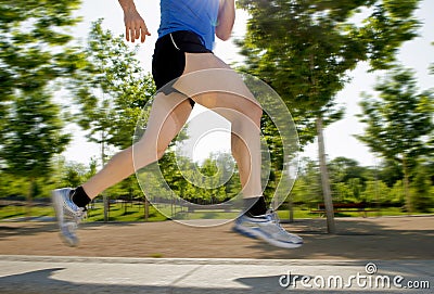 Close up athletic legs of young man running in city park on summer training in healthy lifestyle concept Stock Photo