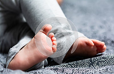 Close up on a Baby Feet on a Bed with a Black Sheet Stock Photo