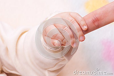 Close-up of baby's hand holding mother's finger Stock Photo