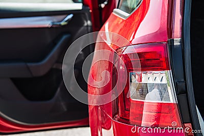 Close up of a back car light. Red car with open side door and trunk. Stock Photo