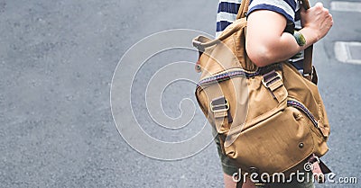 Close up backpack at back of woman traveler walking on street to Stock Photo