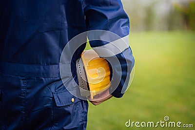 Close-up backside view of engineering male construction worker holding safety yellow helmet Stock Photo