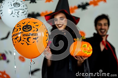 Close up balloon pumpkin. Young couple party and celebrate with Halloween pumpkin and cocktails background. Stock Photo