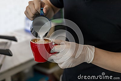 Close up barista pouring steamed milk into coffee cup making beautiful latte, cappuccino art Rosetta pattern. Close up barista Stock Photo