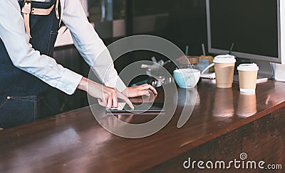 Close up barista waitress wear jean apron using tablet on count Stock Photo