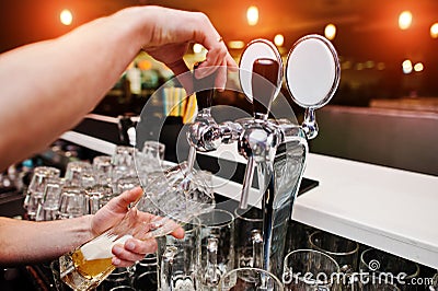 Close up of barman hand at beer tap Stock Photo