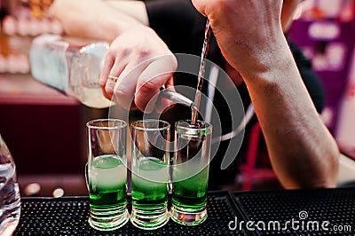 Close up barman hands preparing green mexican cocktail drink at Stock Photo