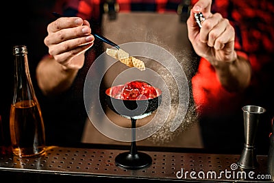 Close-up. Bartender gently decorates glass with cold drink Stock Photo
