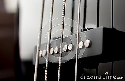 Close-up bass guitar pickups and strings. Musical instruments. Black guitar deck Stock Photo