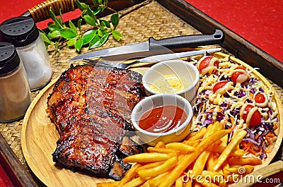 Close up of BBQ RIBS Grilled Steak set with French Fried and Salad on Bamboo Tray Background Stock Photo