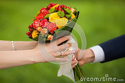 Close up of beautiful bouquet of fresh flowers. man and woman hands. happy bride, groom over summer green park background. Stock Photo