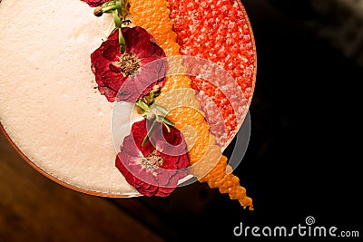 Close-up of beautiful dried flowers and orange peel decorating glass of frothy cocktail Stock Photo