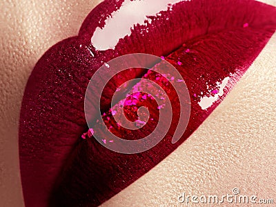 Close-up of beautiful full woman's lips with bright fashion gloss pink makeup. Macro shot with magenta lip Stock Photo