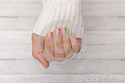 Close-up. Beautiful groomed woman`s hands with colored nails on the wooden background. Manicure, pedicure beauty salon concept. Stock Photo