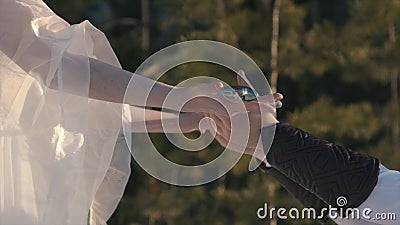 Close-up of beautiful woman`s hand in white dress handing a large Medieval sword to the knight. Action. Historical edged Stock Photo