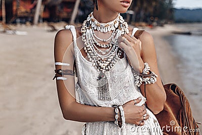 Close up of beautiful young stylish boho woman walking on the beach at sunset Stock Photo