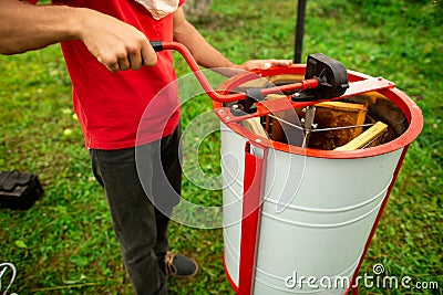 Close up of beekeeper hands, launches into work a honey extractor on the bee farm. Beekeeping Stock Photo