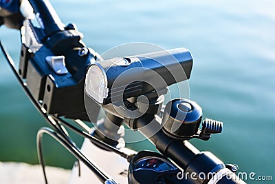 Close-up of bicycle front light and bell on a handlebar. Bicycle accessories Stock Photo