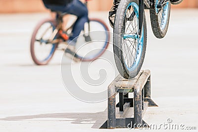 Close-up of bicycle wheels doing trick by rail Stock Photo