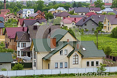 Close-up of big new comfortable two-storied new cottage with green tile roof, big yard, plastic windows and high chimneys in mode Stock Photo