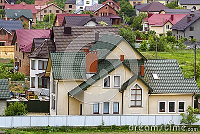 Close-up of big new comfortable two-storied new cottage with green tile roof, big yard, plastic windows and high chimneys in moder Stock Photo