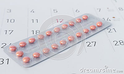 Close up birth-control pill with date of calendar background Stock Photo