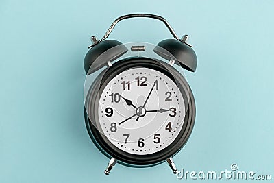 Black alarm clock on blue Stock Photo