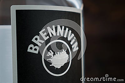 Close-up of a black Brennivin label against a dark wooden background. Selective focus. Traditional Icelandic spirits. Editorial Stock Photo