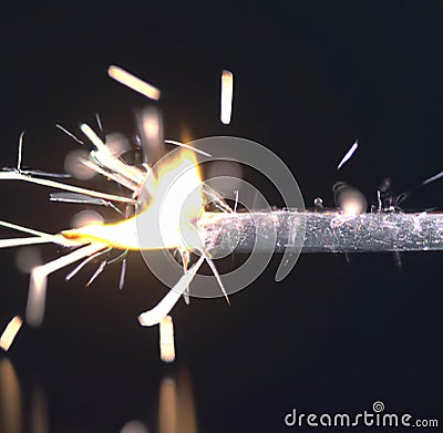 Close up of black burned sparkler producing multiple sparks, created using generative ai technology Stock Photo