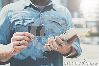 Close-up of black empty credit, business, calling, visiting card in hand of young businessman, standing outdoors. Stock Photo