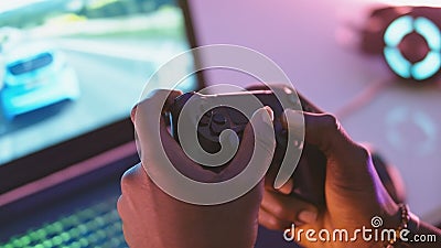 Close up of black man hands holding joystick and playing video game on the laptop Stock Photo