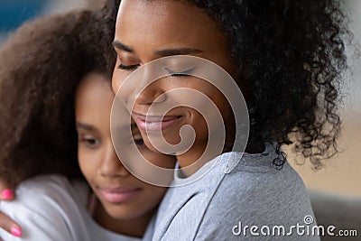 Close up of black mom hugging teenage daughter Stock Photo