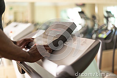 Close up of black person setting up cardio machine in gym Stock Photo