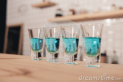 close up of blue cocktails in shot glasses standing on bar counter Stock Photo