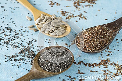 Wooden spoons with sunflower seeds, chia and linseed Stock Photo