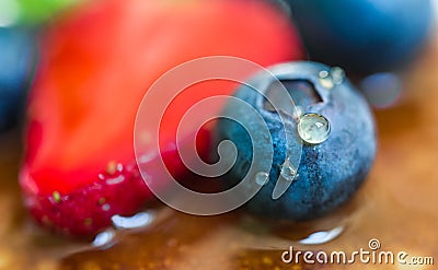 Close up of a blueberry with a drop of honey on the stack of pancakes. Stock Photo
