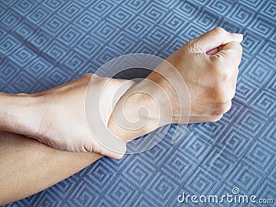 Close-up of body hand suffering with wrist pain stretching arms on bed Stock Photo